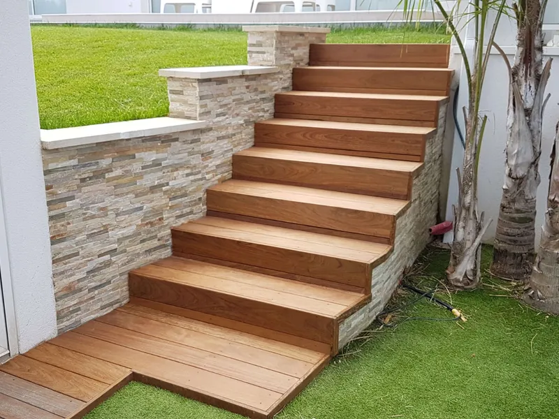 Escalier extérieur en itauba adossé à un mur en pierre dans le Pays d'Aix