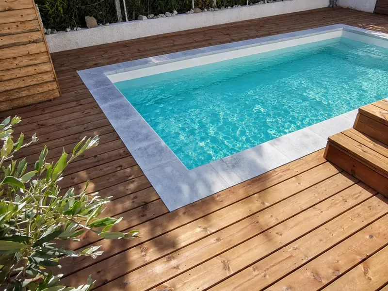 Plage de piscine en pin du Nord thermotraité avec margelles en pierre
