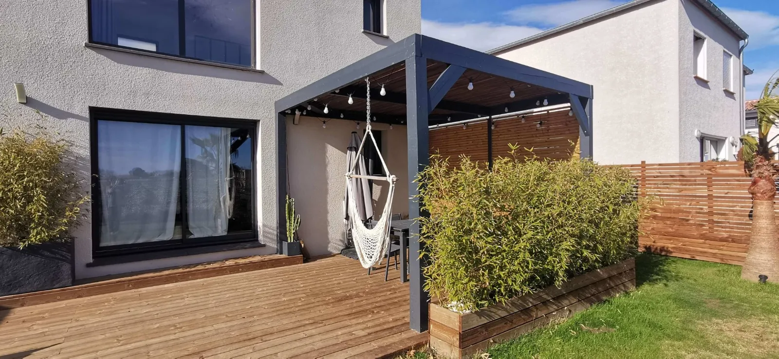 Pergola bois sur mesure au-dessus d'une terrasse bois, aménagement extérieur dans le Pays d'Aix